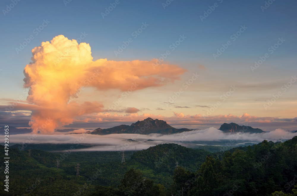 Beautiful sea of fog in the mountains, high voltage pole and steam from the coal power plant in the morning sunrise . Mae moh, Lampang, Thailand. Energy and environment concept .