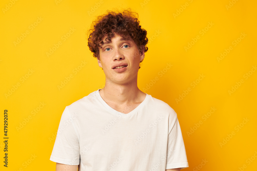 Cheerful guy with curly hair in a white T-shirt Youth style