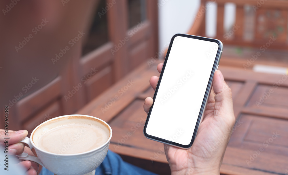 Mockup image blank white screen cell phone. Man hand holding, using mobile relax on sofa at home. background empty space for advertisement