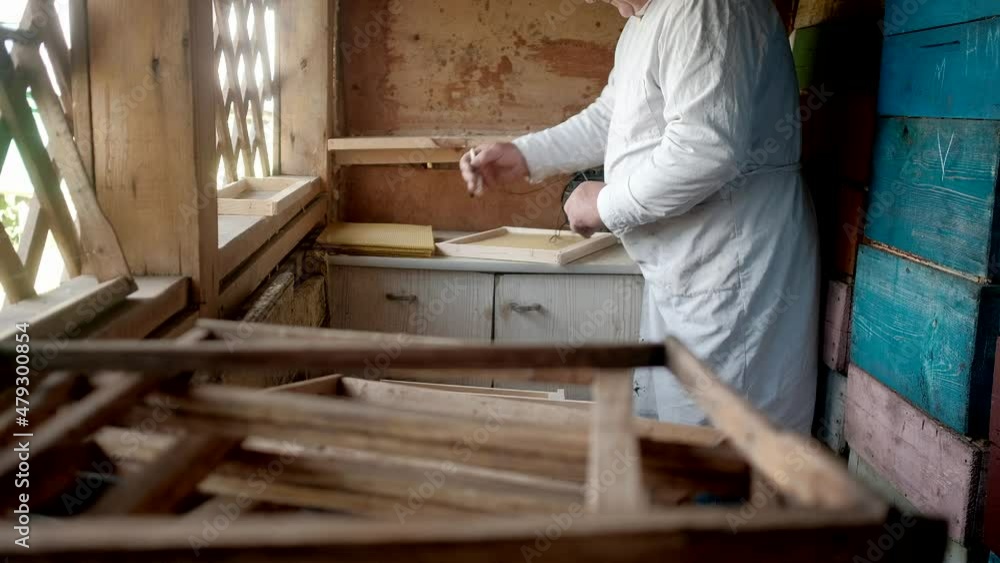 Preparing a wax frame for beehings with bees. The theme of beekeeping and honey. Close-up of the beekeeper's hands. creating and fixing wax frames for bees. electric welding. Preparing a wax frame for beehings with bees. The theme of beekeeping and honey. Close-up of the beekeeper's hands. creating and fixing wax frames for bees. electric welding.