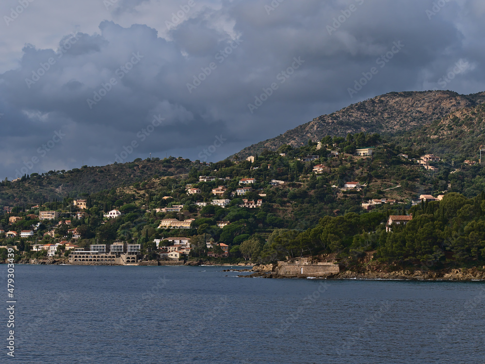 Beautiful view of the rocky mediterranean coast near town La Lavandou at the French Riviera, France on cloudy day in autumn season with houses.