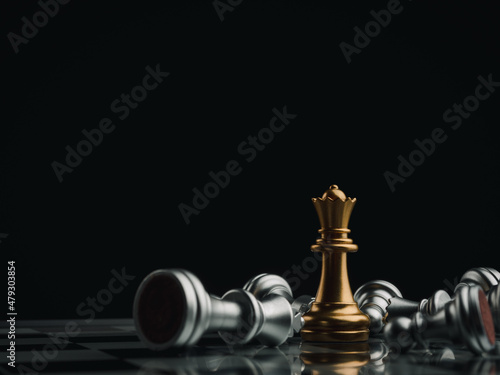 Canvastavla The gold queen chess piece standing with falling silver pawn chess pieces on chessboard on dark background with copy space