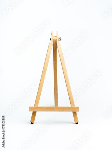 Wooden easel isolated on white background, vertical style. Advertising mockup for artboard, pictures, or painting artwork. Easel standing display.
