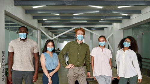 Multiracial people in medical masks in office