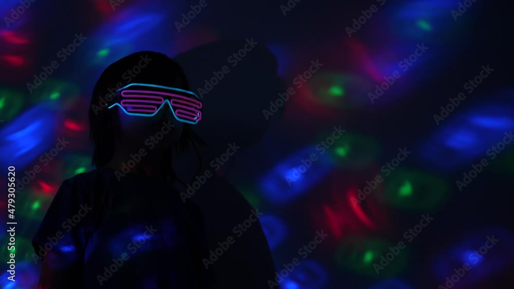boy child dances at a disco in neon glasses, plays in the metaverse in virtual reality boy child dances at a disco in neon glasses, plays in the metaverse in virtual reality