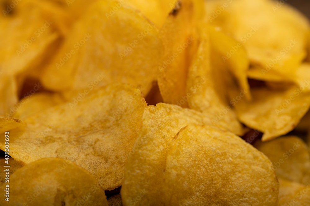 Potato chips scattered on the table, close-up, selective focus. Potato chips scattered on the table, close-up, selective focus.