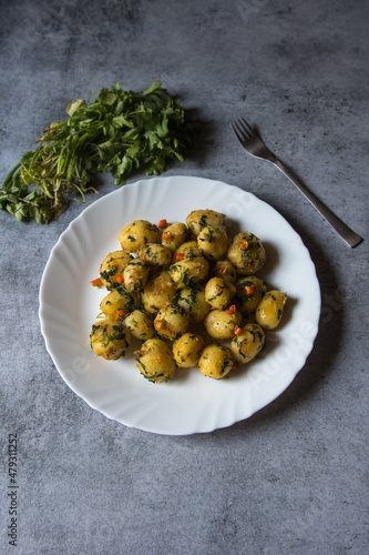 Bilde på lerret Dum aloo or fried baby potatoes tossed in oil in a white plate