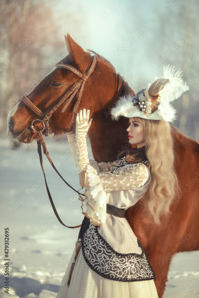 A blonde girl with a horse in the winter forest in a historical costume. Art photo A blonde girl with a horse in the winter forest in a historical costume. Art photo