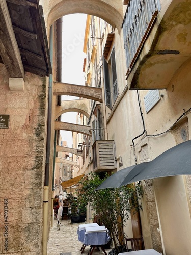 Bonifacio, Corsica, 26.07.2021. Narrow alleyway with restaurant tables in the picturesque old town of Bonifacio. 