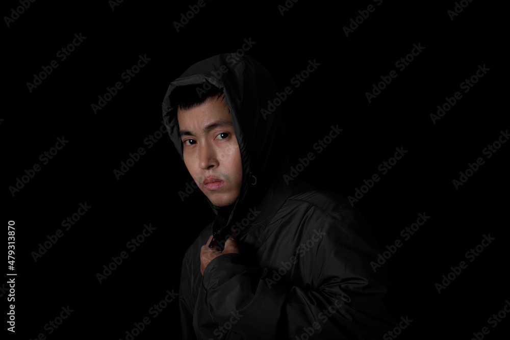 Man wear overcoat with hood on head on black background. Concept of fashion and stylish male.