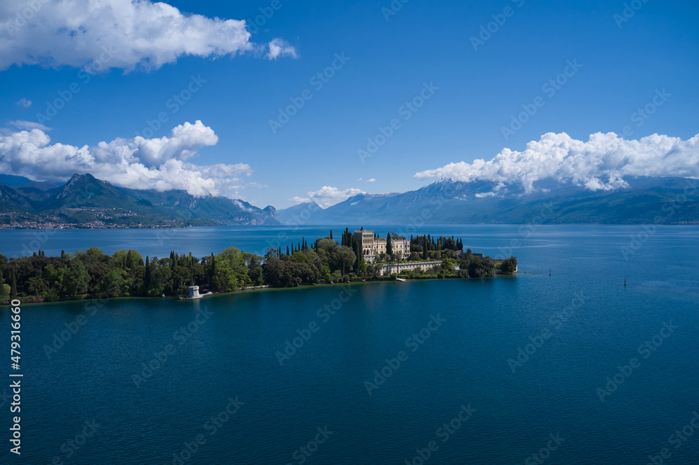Magnificent aerial panorama of Isola del Garda, Lake Garda, Italy. Castle on an island in Italy. An island surrounded by the Italian Alps. Isola del Garda, Italy. Historic sites on Lake Garda.