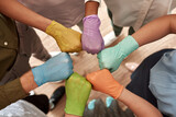Multiracial employees in medical gloves bump fists