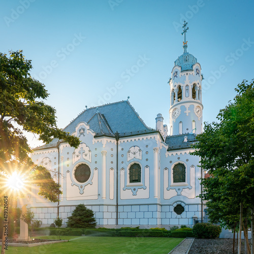 Blue church in Bratislava with blue sky and green grass, romantic tourist site