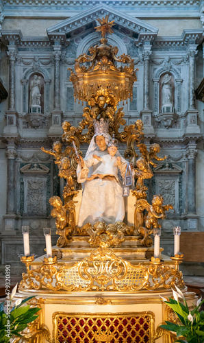 Gilt statue of St Mary with baby Jesus and angels, baroque altar in Santa Maria dei Carmini, Venice photo