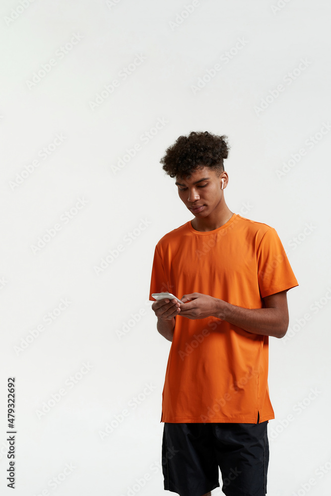 Man in wireless earphones messaging on smartphone Man in wireless earphones messaging on smartphone
