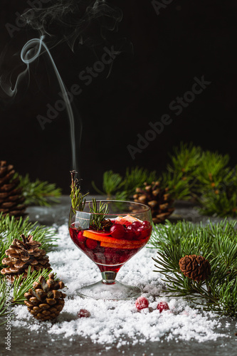 Wallpaper Mural Mulled red cherry wine or punch on a snow covered background and spruce branches. Rosemary burns and smokes.Christmas beverage. Torontodigital.ca