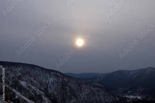 Sunset in the mountains. Mountain landscape in winter. Snow-covered rocks. Bad weather in the mountains. 