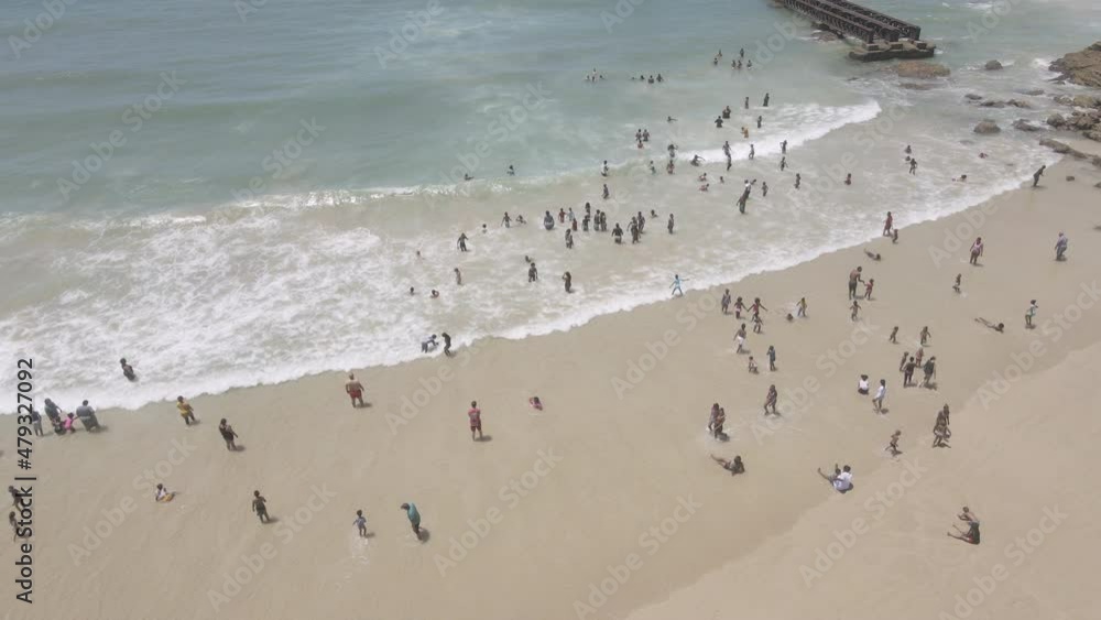 Drone flying over coastline with people seen swimming Drone flying over coastline with people seen swimming