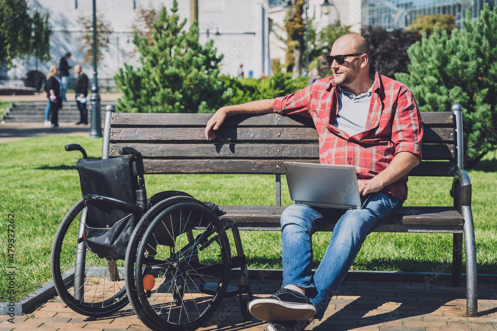 Freelancer with a physical disability who uses wheelchair working at the park Freelancer with a physical disability who uses wheelchair working at the park