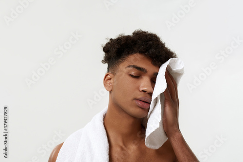 Black tired sportsman wiping face with towel