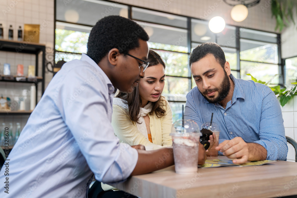 Group of business people sitting at the coffee shop or cafe and looking at camera and discuss on work. Manager of the project smile and success on the job. Business and successful concept