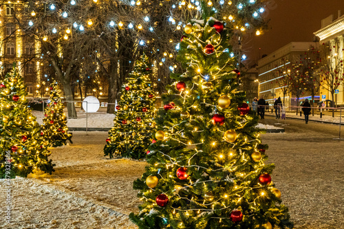 outside Christmas and new year tree with golden light decoration at night party in winter