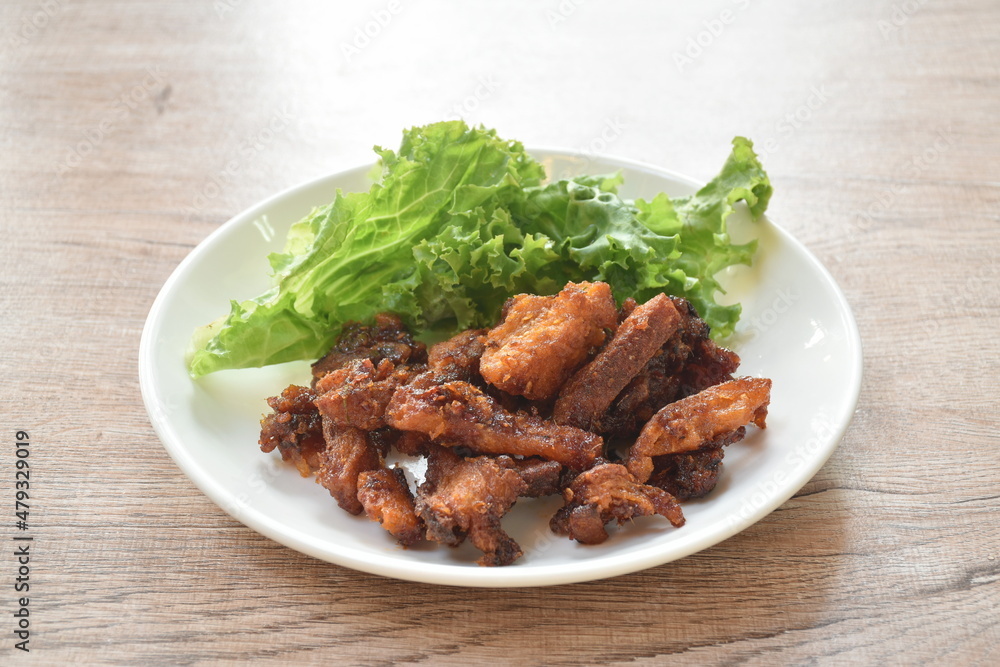 crispy fried pork belly with chili sauce and lettuce on plate crispy fried pork belly with chili sauce and lettuce on plate