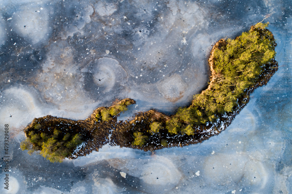 A stunning aerial view to a frozen bog lake with a small island in Estonian wilderness. A stunning aerial view to a frozen bog lake with a small island in Estonian wilderness.