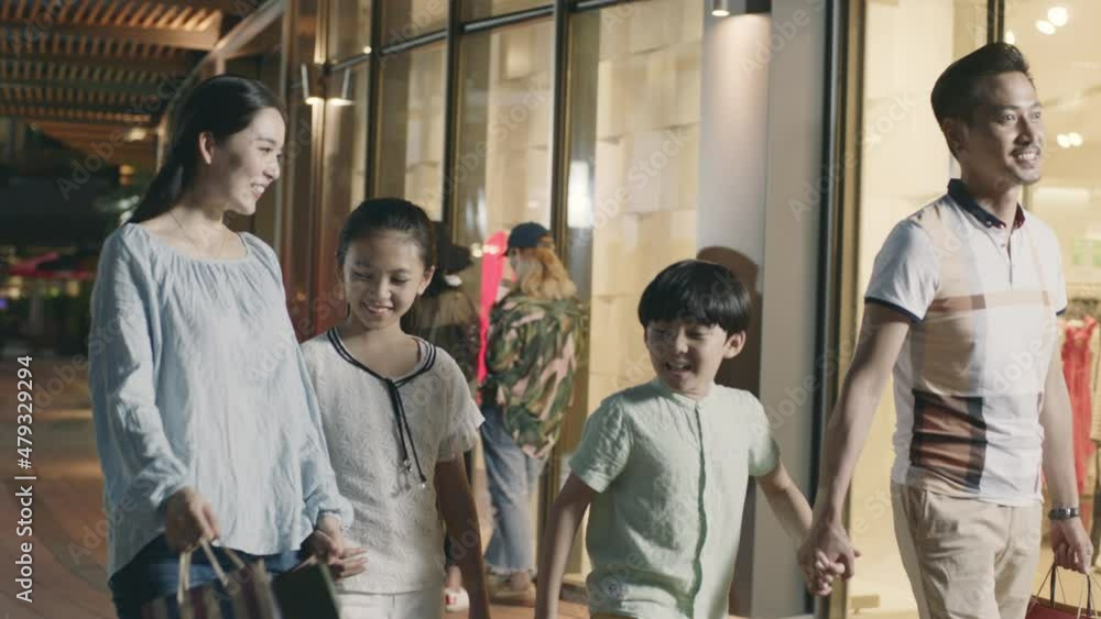 Asian family parents and kids walking outside of shopping mall Asian family parents and kids walking outside of shopping mall