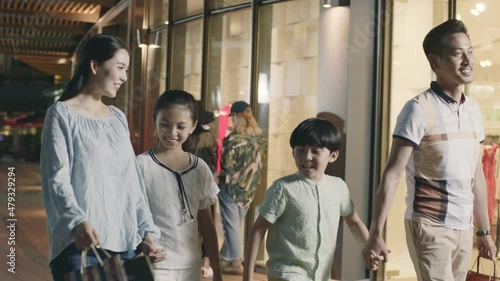Asian family parents and kids walking outside of shopping mall