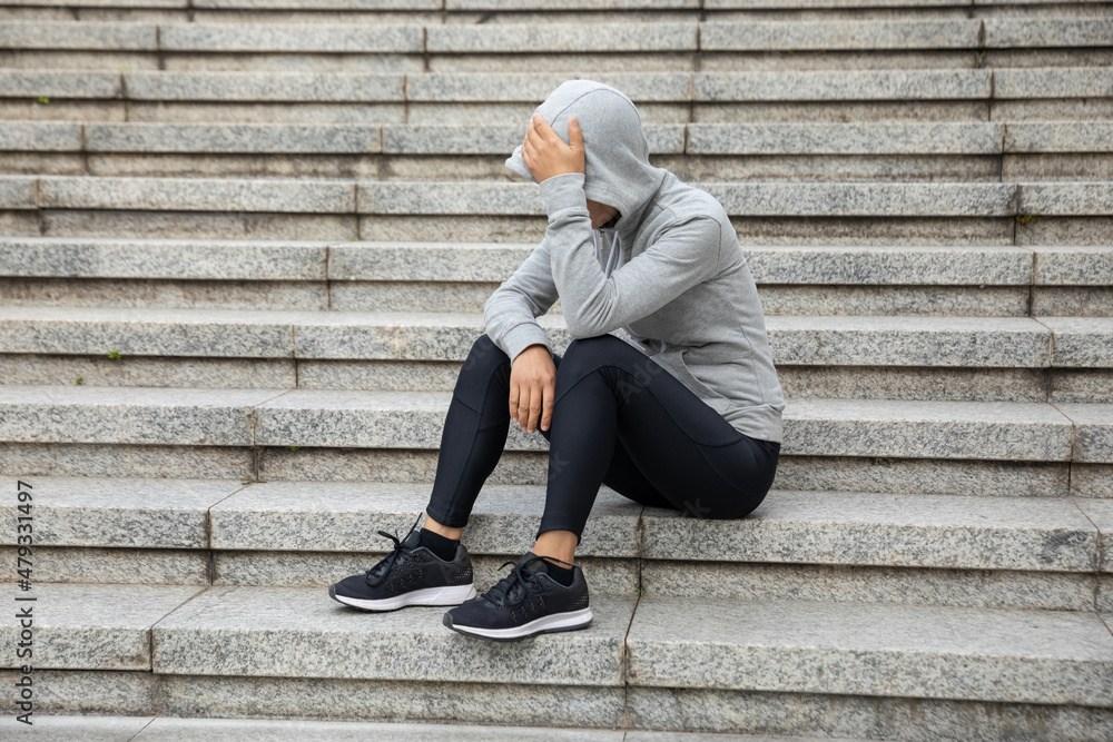 Upset woman sitting alone in city stairs