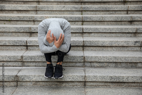 Upset woman sitting alone in city stairs photo