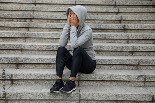 Upset woman sitting alone in city stairs © lzf