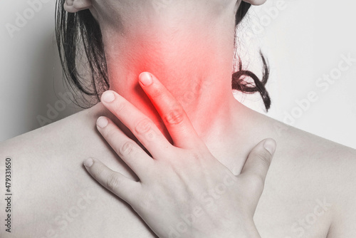 Woman with sore throat is touching her neck