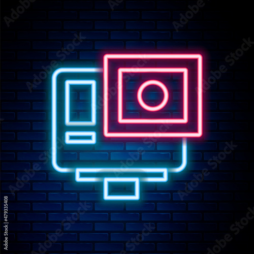 Glowing neon line Action extreme camera icon isolated on brick wall background. Video camera equipment for filming extreme sports. Colorful outline concept. Vector