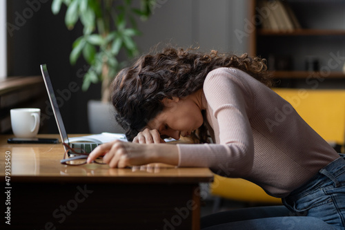 Work burnout. Tired exhausted female employee feeling energy depletion or exhaustion, overworked stressed female putting head down on table, suffering from chronic job stress. Overwork concept photo