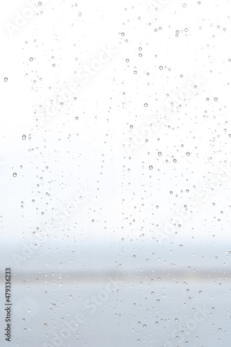 Sky background with water drops on a glass window