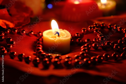  Fortune-telling on fire and a ring  Russian divination for love at Christmas. Burning red candles  heart shaped candles  ruby       beads on the table. Occult concept. February 14 decoration.