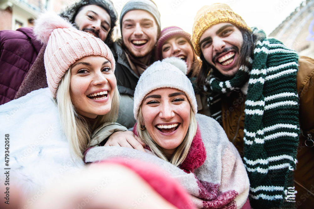 Happy friends wearing winter clothes taking selfie outdoors - Group of young people having fun on city street - Funny women and men smiling at camera - Friendship and happy lifestyle concept