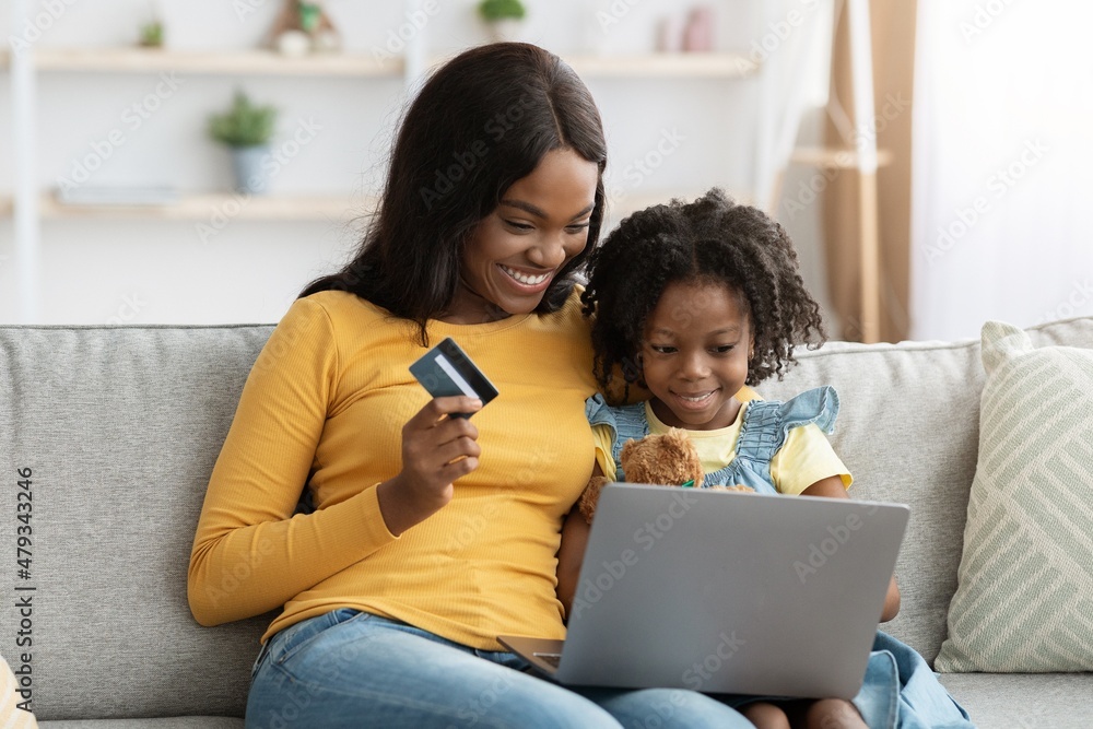 Happy Black Mother And Daughter Shopping Online With Computer And Credit Card Happy Black Mother And Daughter Shopping Online With Computer And Credit Card