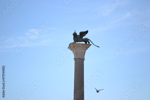 Ancient historic column with the griffin statue in Venezia. Blue sky background, ancient monument.