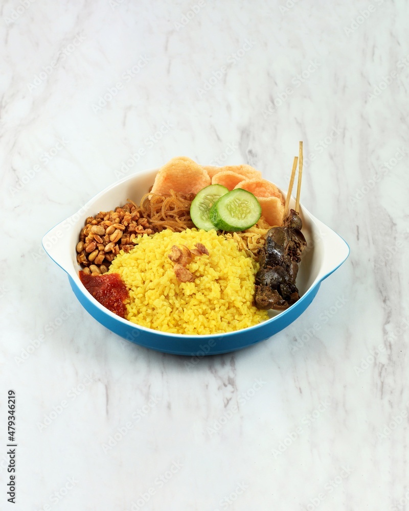 Fototapeta premium Nasi Kuning (Yellow Rice), Indonesian Traditional Steamed Rice with Turmeric, Coconut Milk, and Other Spice. Usually Served for Breakfast in Indonesia with Tempeh, Bihun, Noodle, and Egg.