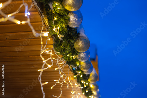 Winter decoration of the facade of the building-pediment with a garland of spruce balls and nets.
