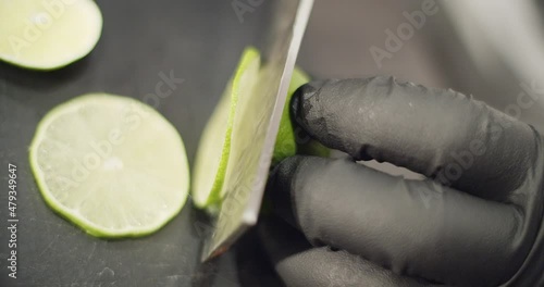 Cocktail series. Bartender preparing a Peruvian cocktail called Pisco Sour, in a bar with a relaxed atmosphere in slow motion, add ice, lime and mix the drink wearing black gloves as biosecurity.