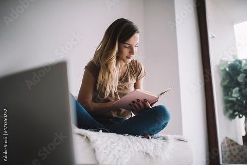 Valokuvatapetti Intelligent female student 20s checking informative notes from textbook during e