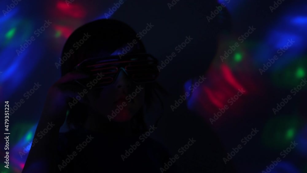 boy child dances at a disco in neon glasses, plays in the metaverse in virtual reality boy child dances at a disco in neon glasses, plays in the metaverse in virtual reality