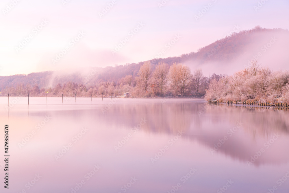Mountain in Maastricht on an early winter morning during sunrise with amazing pastel colors. The mountain is covered with veils of fog creating a magical environment