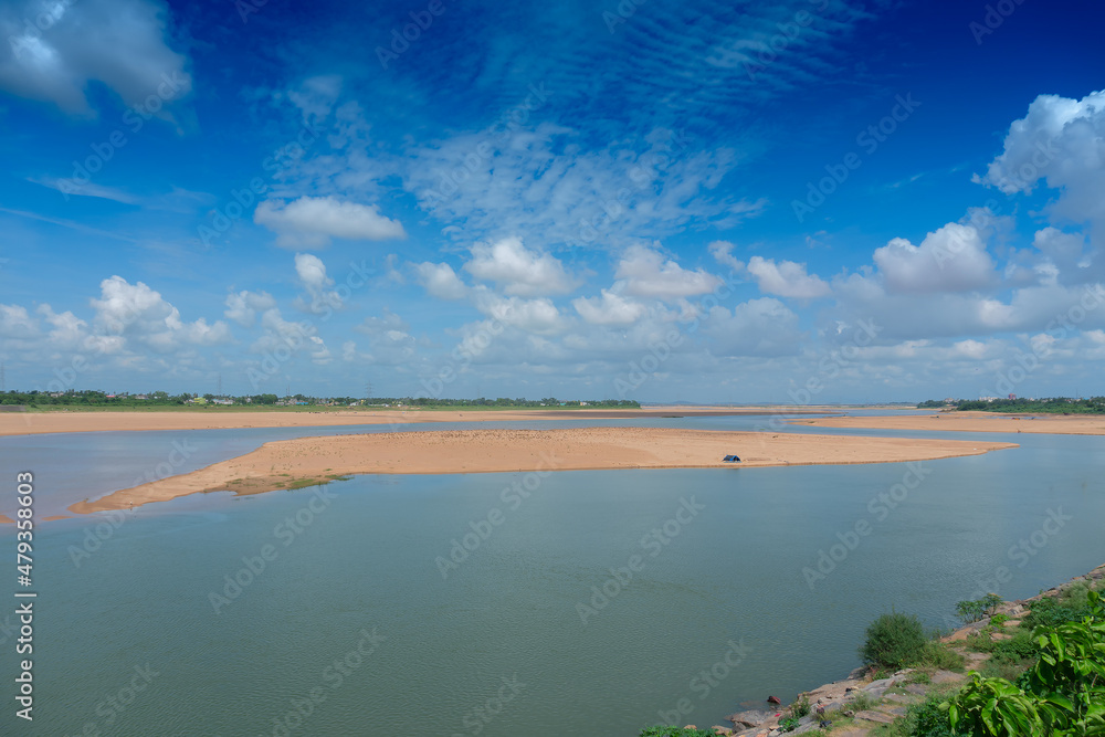 Beautiful landscape image of Mahanadi river of Odisha, with blue sky and white clouds in the background. Nature stock image of Odisha with copy space.