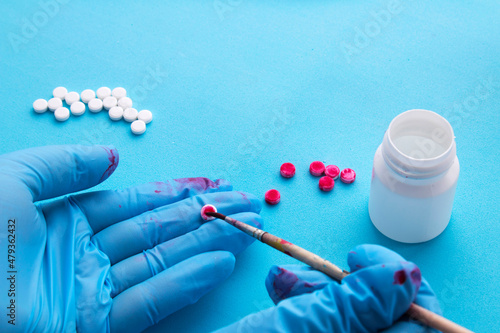Counterfeiting drugs. Gloved hands counterfeiting pills.