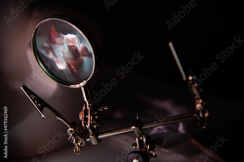 The magnifying glass reflects the still life. Selective focus. Low key photography. Copy space